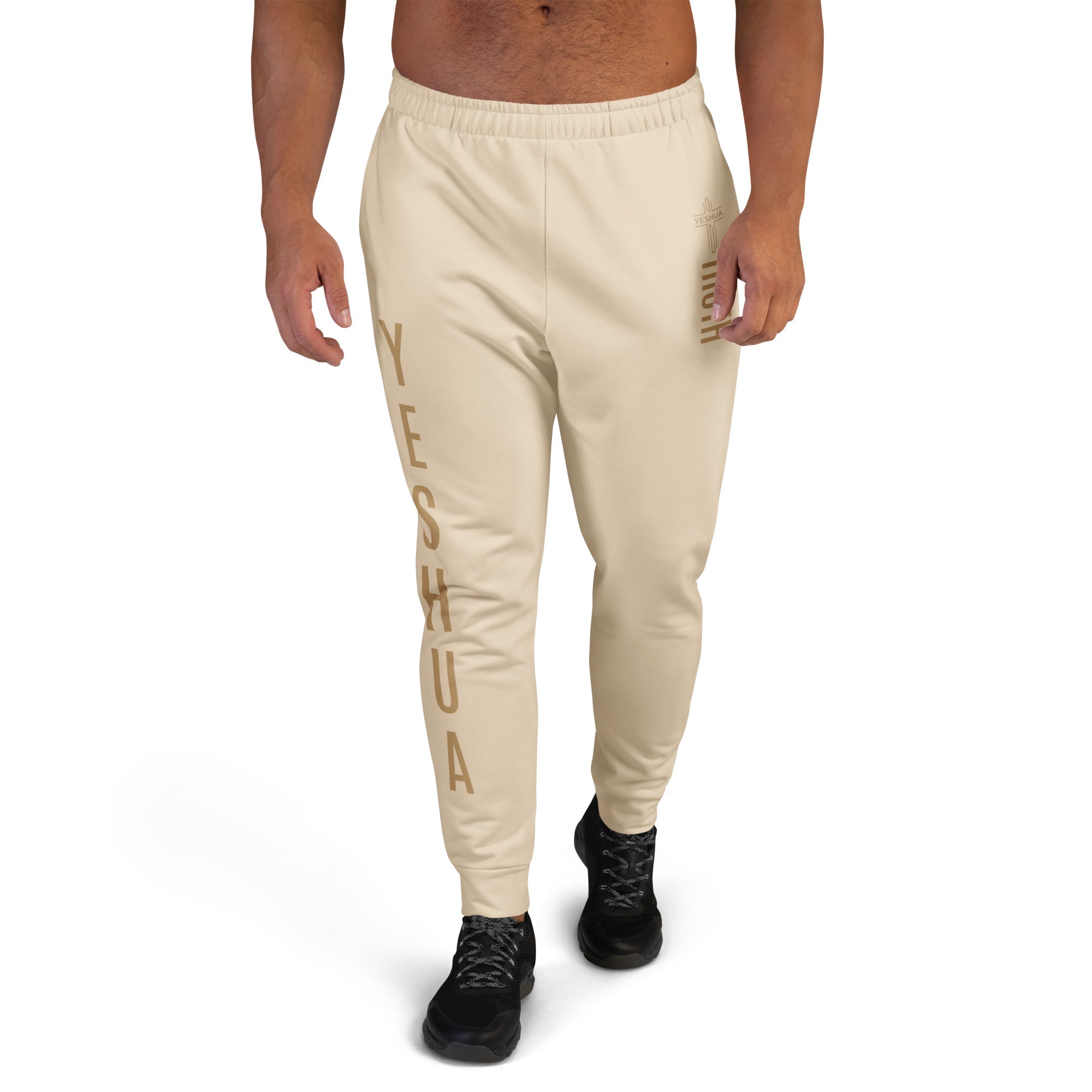 Beige sweatpants with 'Yeshua' text worn by a person on a white background